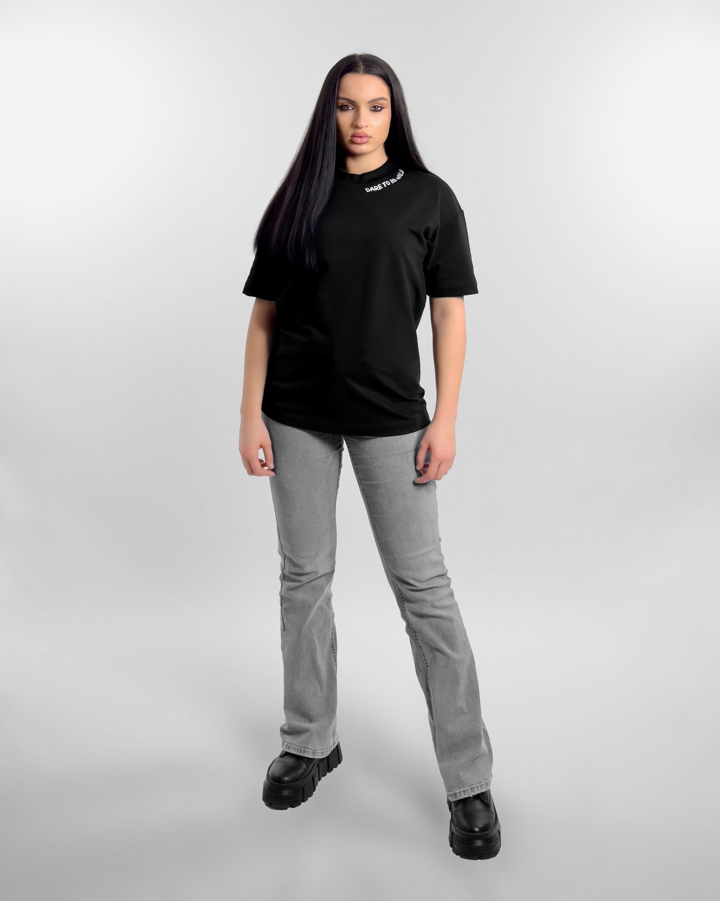 Femeie purtant tricoul negru oversize MANNIC cu printul DARE TO BE WILD, cadru frontal